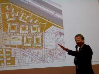 Baudezernent Bodemann vor Plan der Wasserstadt