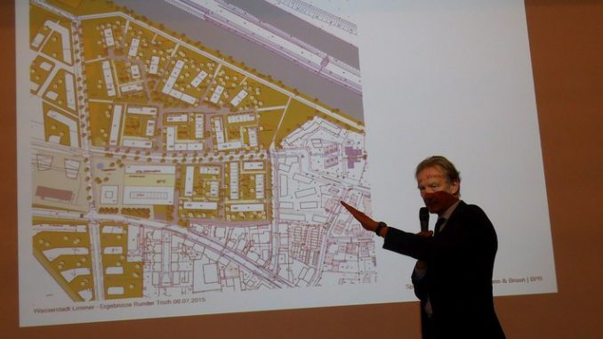 Baudezernent Bodemann vor Plan der Wasserstadt