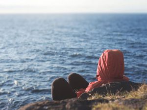 An der Küste sitzen, weiter Blick aufs Meer
