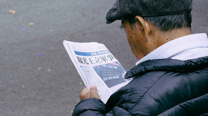 Zeitungsleser auf der Parkbank