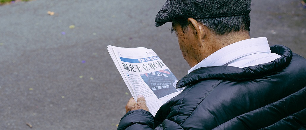 Zeitungsleser auf der Parkbank