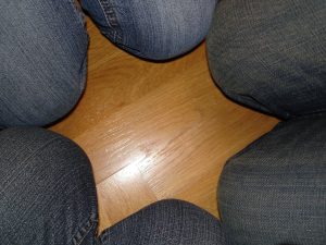 Figur-Grund-Phänomen, 6 Kniee in Jeans formen einen Stern auf Parkett