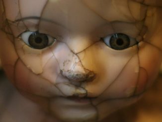 zerbrochenes Gesicht einer alten Puppe