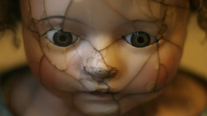 zerbrochenes Gesicht einer alten Puppe